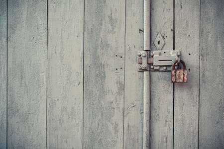 Closeup vintage old wooden door in grungy style with padlockの写真素材