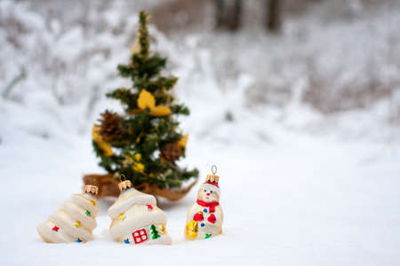 some Christmas toys in the snow near a Christmas tree