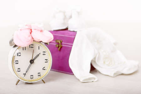 Retro alarm clock with things for babies over white backgroundの写真素材