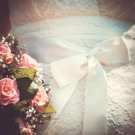 Wedding bouquet on white dress with bow. vintage wedding theme background