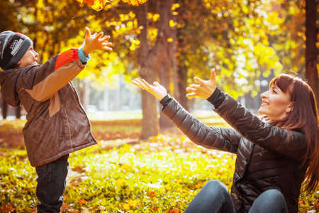 Beautiful mother with son in autumn park Nature photo sceneの写真素材