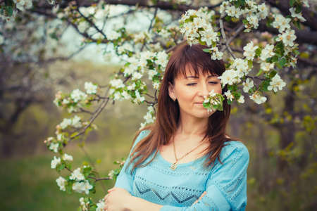outdoor portrait of beautiful girl near bloomin apple treeの写真素材