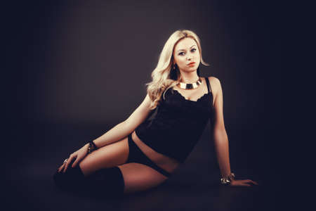 Fashion portrait of beautiful blonde woman over black background