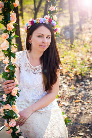 Beautiful woman with flower wreath.Beautiful women in the countryside.Portrait of beautiful young girl outdoors in springの写真素材