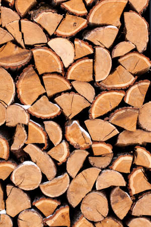 Cutting firewood stacked outside in the snow