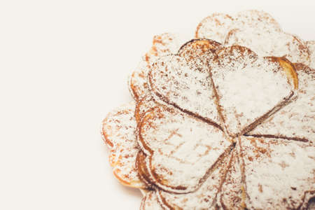 Waffle heart-shaped dusted with icing sugar macro photoの写真素材