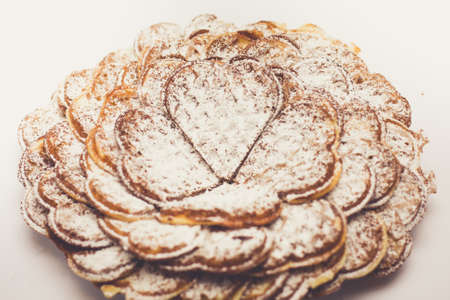 Waffle heart-shaped dusted with icing sugar macro photo