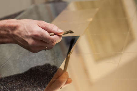 Master works with a thin gold leaf pieces on glass hands in the center of the frame