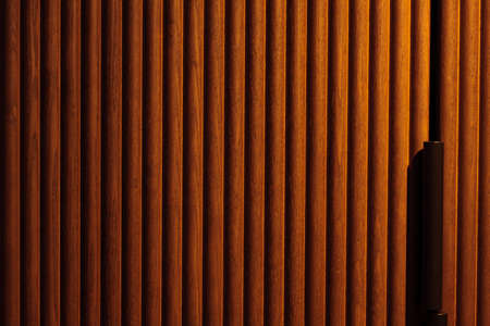 groovy red brown wood panel with abstract vertical lines pattern, background with a gradient illuminationの写真素材