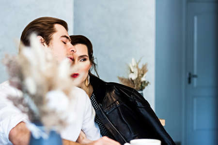 beautiful couple in a cafe at a table drinks coffee and talking about something