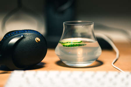 Gin and tonic with headphones on a working deskの写真素材