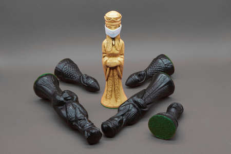 white chess queen figure with face mask, beating the black chess pieces. The queen's checkmate to...