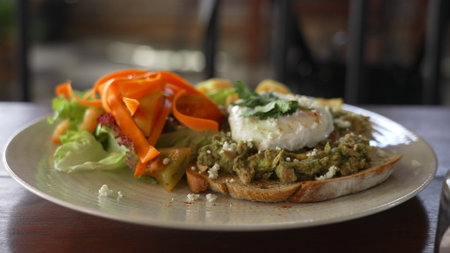 Tasty smashed avocado toast and poached egg with vegetable salad and cheese. Delicious egg Benedict...