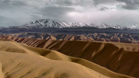 A unique landscape of wild nature with a valley of yellow sand dunes against the background of a...