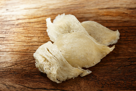 The nest of Edible-Nest Swiftlet, raw edible bird's nest materials for tradition chinese medicine. Edible nest soup is popular at Hong Kong, Taiwan, China and Southeast Asia. Selective focus and free space for text. Edible bird's nest on white background.の写真素材