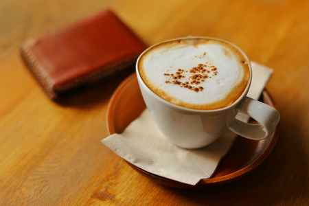 Hot coffee on rustic wooden table, Close up coffee with milk on top, selective focus, free space for text and toned image.の写真素材