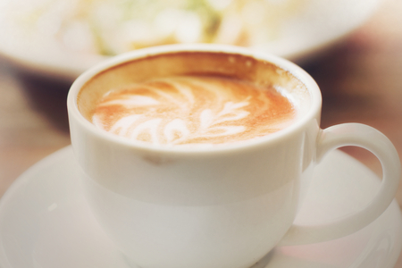 Hot coffee on wooden table, The best materials for processing fresh coffee. Porcelain coffee cup on table with breakfast, Selective focus and free space for text. Industrial food and drink concept.の写真素材