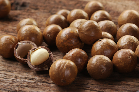 Roasted macadamias on wooden table, selective focus and toned image. Healthy food concept, free space for text.の写真素材