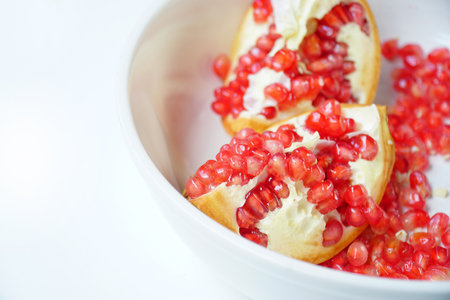 Close up of Pomegranate seeds on white background. Selective focus and free space for text. Healthy fruits concept.の写真素材