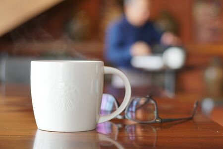 Hot coffee on wooden table, The espresso prefect shot, fresh coffee with smoke. Business time with coffee, selective focus and free space for text, Industrial food and drink concept.の写真素材