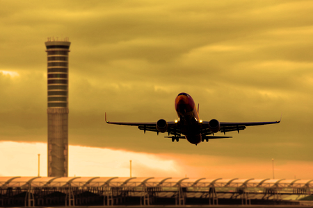 Silhouette of airplane in cloudscape. Low angle shot of The airplane flying across camera in beautiful sky. Transportation by airplane concept.のeditorial素材