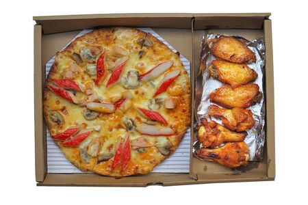 Pizza and grilled chicken wings in paper box isolated on white background. This image stacked  for advertising. ideas concept.の写真素材