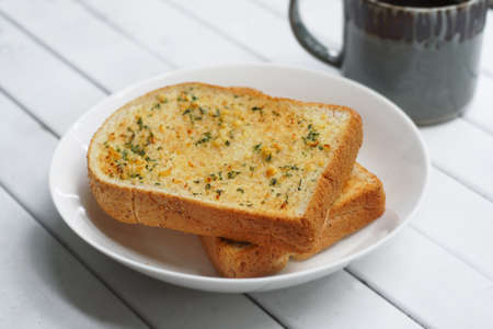 Weed garlic bread, Toasted bread with garlic and marijuana leaves served with hot coffee on white...