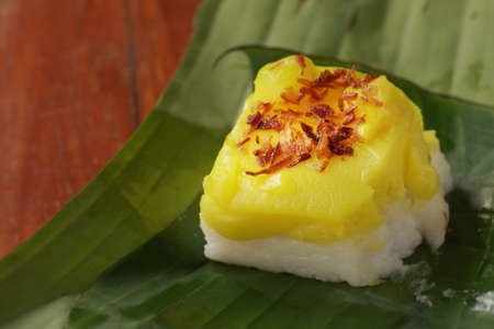 Thai dessert called Khao Khaek is traditional thai dessert, sweet rice with yellow coconut milk on top. Khao Khaek on banan leave, selective focus and free copy space.の写真素材