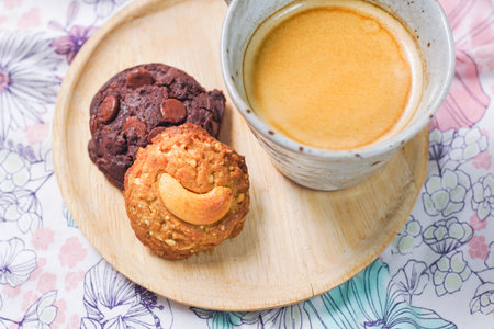 Coffee break with a cup of hot coffee and chocolate, nut cookies, served on a table.の写真素材