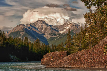 Fast streaming river skirts red rocks and trees in fall colors.の写真素材