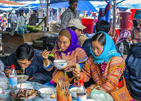 Vietnam Bac Ha - March 2012: Hmong people eating on Sunday market.のeditorial素材