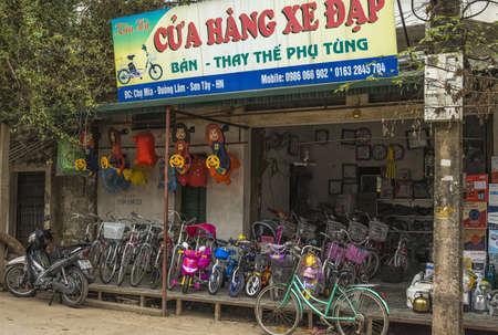 Duong Lam, Vietnam - March 8, 2012: Bike shop in rural village. Big sign on top of displayed bikes in different sizes and colors.のeditorial素材