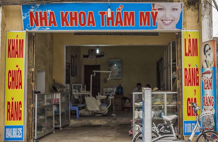 Duong Lam, Vietnam - March 8, 2012:Dental office in rural village. Front of office framed in advertisement posters looks into dental workplace.のeditorial素材