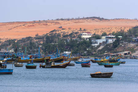 South Vietnam Mui Ne village  The dunes tower over the sea with its many fishing vessels の写真素材