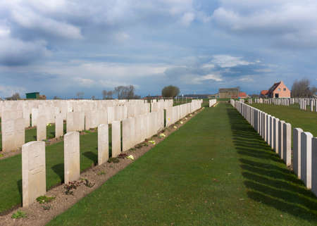 IEPER, BELGIUM - CIRCA MARCH 2014: Belfry of Ypres (Ieper) with Flanders Fields Museum. Rows of tombs at Bard Cottage Cemetery in Ypres, Flanders, Belgium - Landscape.のeditorial素材