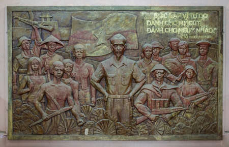 QUANG TRI, VIETNAM - CIRCA MARCH 2012: Bas-relief of Ho Chi Minh with troops and workers. Bronze...