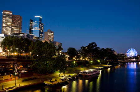 MELBOURNE, AUSTRALIA - CIRCA NOVEMBER 2009  View over Yarra River showing the night skyline of downtown with a blue-lighted ferris wheel in the background のeditorial素材