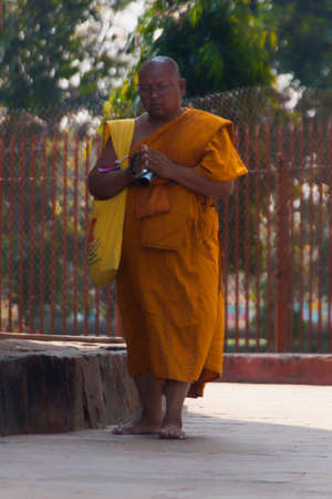 VARANASI, INDIA - CIRCA FEBRUARY 2011  Buddhist monk in orange robe circles the Dhamekh Stupa のeditorial素材