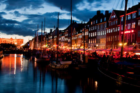 COPENHAGEN, DENMARK - CIRCA SEPTEMBER 2010: The most colorful side of Nyhavn with restaurant row and the sloops in the water at night fall.のeditorial素材