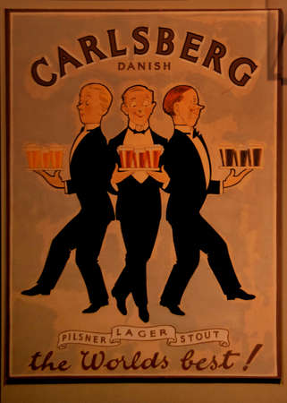 COPENHAGEN, DENMARK - CIRCA SEPTEMBER 2010: Old poster promotes the pilsner, the lager and the stout brewed by the Carlsberg brewery in town. It features three male servants, each with a tray of the specific beers.のeditorial素材