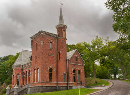 STOCKHOLM, SWEDEN - CIRCA SEPTEMBER 2010: Church at the entrance of Kastelbacken island in Stockholm. Century old building in green setting and circling road.のeditorial素材
