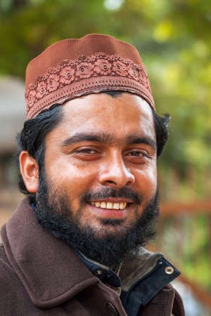 DELHI, INDIA - FEBRUARY 7, 2011: This young, bearded, Muslim man wears a dark brown vest and a light brown cap.のeditorial素材