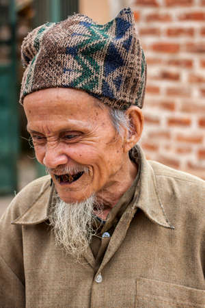 HANOI, VIETNAM - MARCH 8, 2012: An old man, claiming to be in his eighties and a French teacher has extremely bad black teeth.のeditorial素材