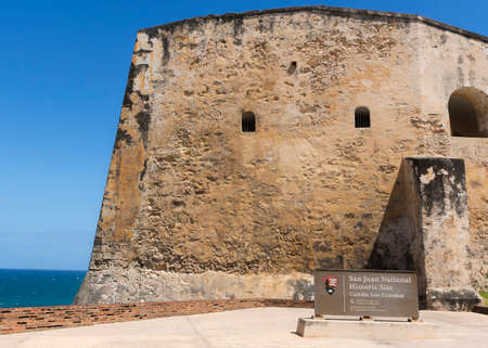 SAN JUAN, PUERTO RICO - MARCH 6, 2015: Official sign at Western entrance of Castillo San Christobal. Ramparts and ocean in the background.のeditorial素材