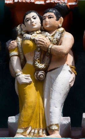 KUMBAKONAM, INDIA - OCTOBER 12, 2013: Mahalingeswarar Temple. Wear and tear have damaged the lesser Gopurams. Cute statue of flirting couple. He holds her breast. Black mold affected the pastel colors.のeditorial素材