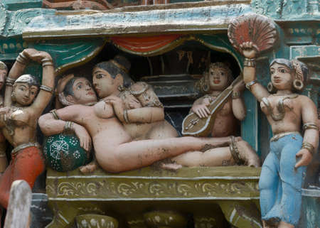 KUMBAKONAM, INDIA - OCTOBER 12, 2013: Sarangapani Vishnu Temple. Focus on Naked, pastel colored statues of one human couple who makes love. The figures are naked. A small selection of the plus hundred figurines on the tower. Weather wear and tear have damのeditorial素材