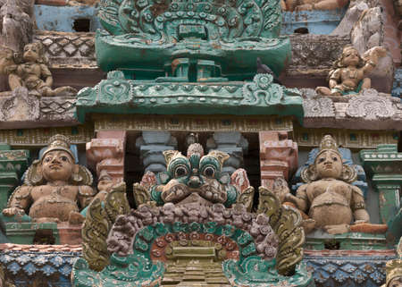 KUMBAKONAM, INDIA - OCTOBER 12, 2013: Sarangapani Vishnu Temple. Focus on two Dwarapalakas, gate keepers, protectors of the temple. A small selection of the plus hundred figurines on the tower. Weather wear and tear have damaged the statues. Black mold isのeditorial素材