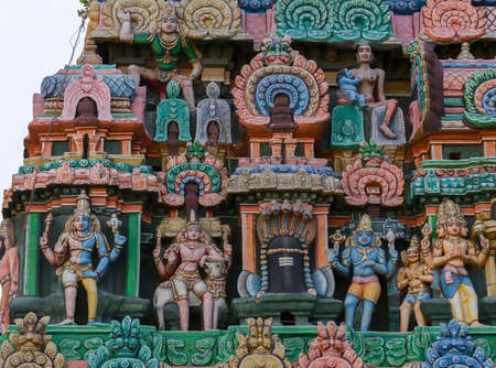 KUMBAKONAM, INDIA - OCTOBER 13, 2013: Kumbeswarar Temple Gopuram. Triumvirate of Hindu gods in the same photo: Shiva, Vishnu, Brahma. Krishna as baby breastfed by Putana. From the left: one person is the pale Shiva and the blue Vishnu. Shiva leaning on Naのeditorial素材