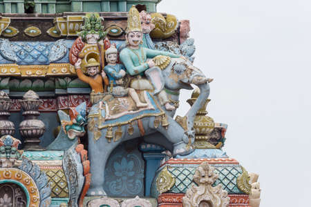 Trichy, India - October 15, 2013: Closeup of  decoration on one Gopuram at Shirangam temple. Three people riding an elephant. One royal. Pastel colors, gray sky.のeditorial素材