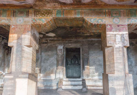 Chettinad, India - October 15, 2013: Shot from entrance of Chithannavasal Cave Temple into the alcove-like inner sanctum, showing the Jain idol. Strong, thick pillars and faded paint on the ceiling and walls.のeditorial素材